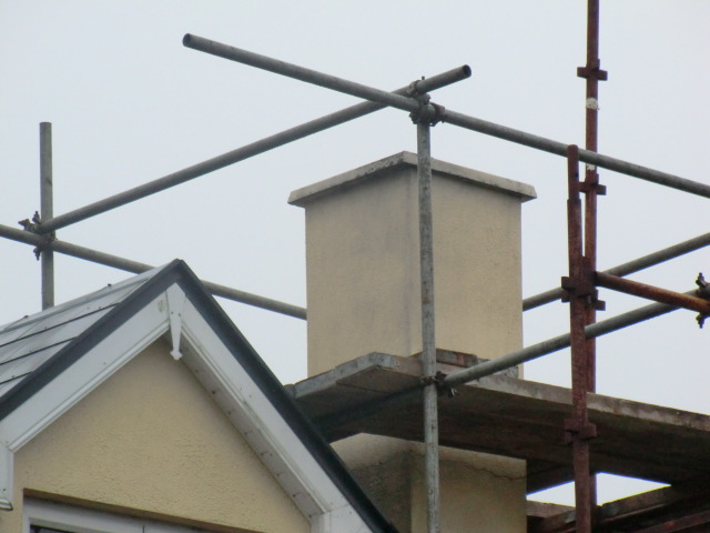Existing chimney stack and scaffolding at roof level for safety